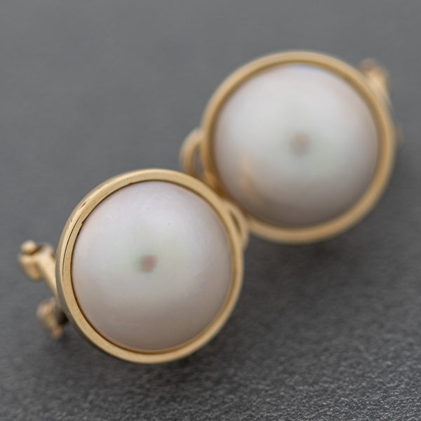 Aretes diseño especial con medias perlas en oro amarillo 14 kilates.