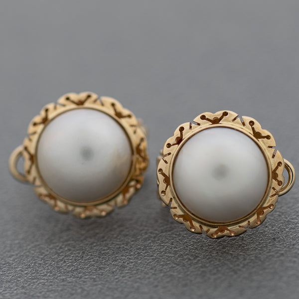 Aretes calados con medias perlas en oro amarillo 14 kilates.