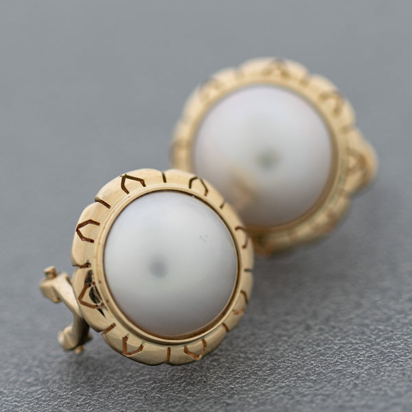 Aretes calados con media perla en oro amarillo 14 kilates.