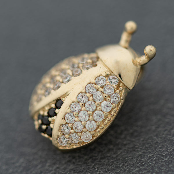 Juego de dije y aretes diseño especial con sintéticos motivo catarina en oro amarillo 14 kilates.