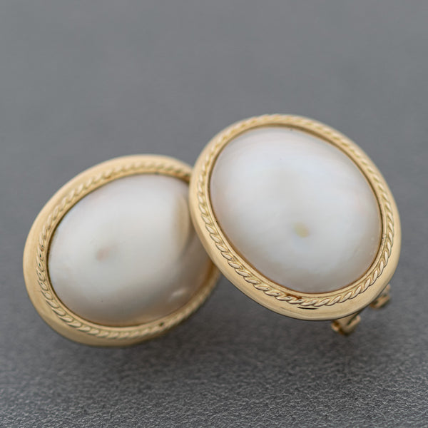 Aretes diseño especial con medias perla en oro amarillo 14 kilates.
