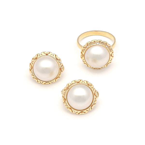 Juego anillo y aretes calados con medias perlas en oro amarillo 14 kilates.