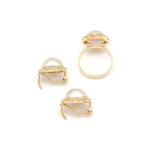 Juego anillo y aretes calados con medias perlas en oro amarillo 14 kilates.