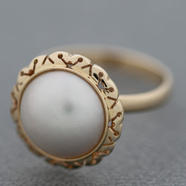 Juego anillo y aretes calados con medias perlas en oro amarillo 14 kilates.