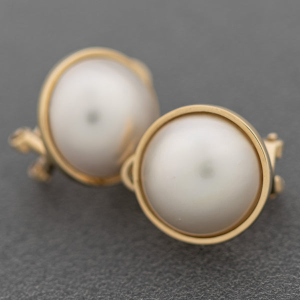 Aretes diseño especial con media perla en oro amarillo 14 kilates.