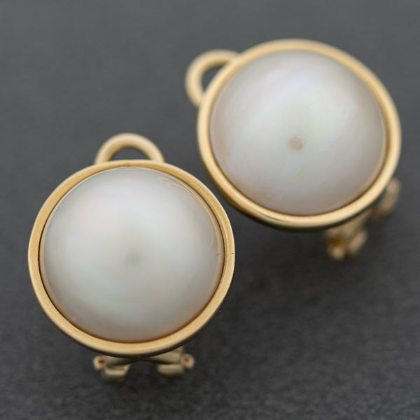 Aretes diseño especial con medias perlas en oro amarillo 14 kilates.