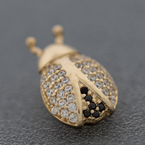 Juego de aretes y dije diseño especial motivo catarina con sintéticos en oro amarillo 14 kilates.