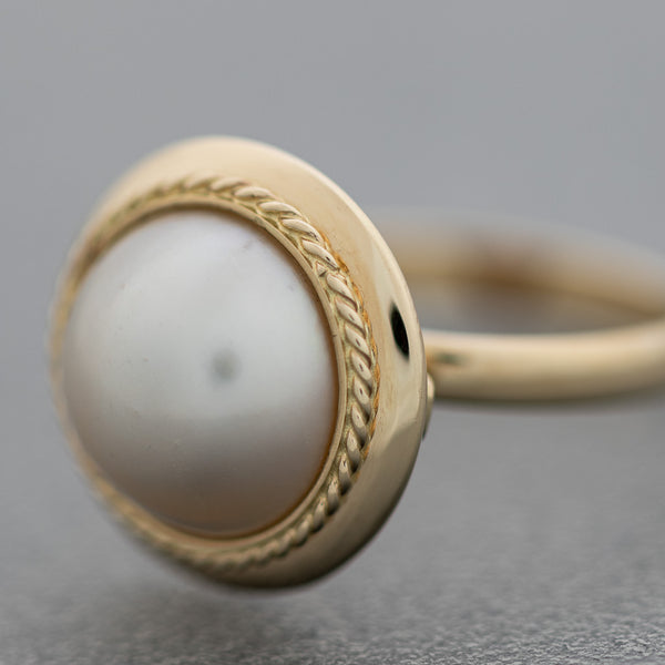 Juego anillo y aretes diseño especial con medias perlas en oro amarillo 14 kilates.