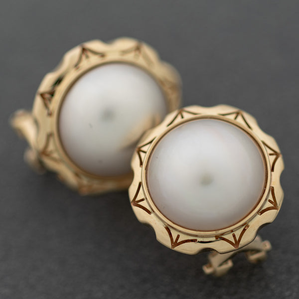 Aretes calados con media perla en oro amarillo 14 kilates.