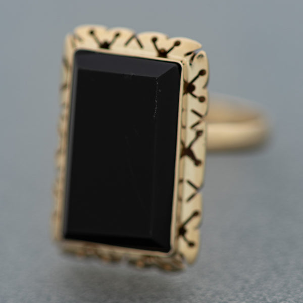 Juego de anillo y aretes calados con ónix en oro amarillo 14 kilates.
