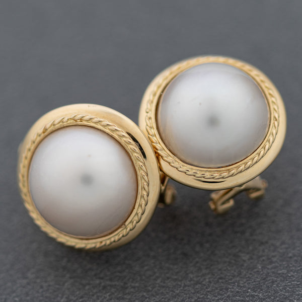 Aretes diseño especial con media perla en oro amarillo 14 kilates.