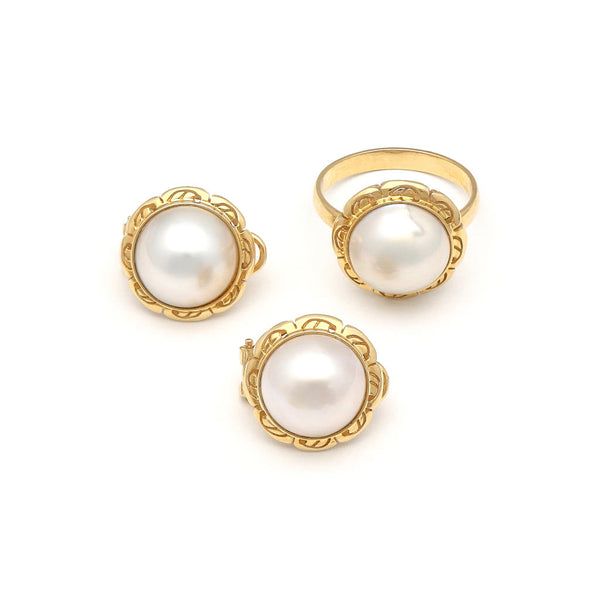 Juego de aretes y anillo calados con medias perlas en oro amarillo 14 kilates.