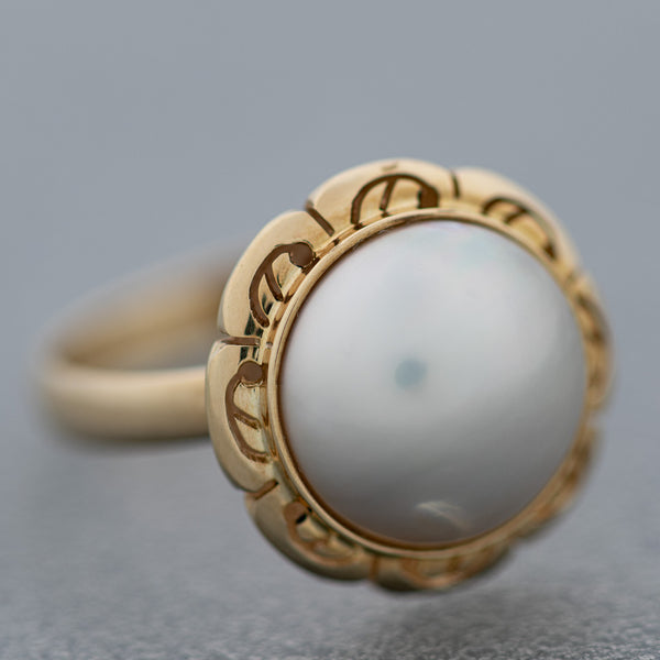 Juego de aretes y anillo calados con medias perlas en oro amarillo 14 kilates.