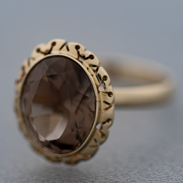 Juego de anillo y aretes calados con topacio en oro amarillo 14 kilates.