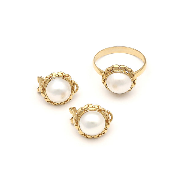 Juego de anillo y aretes calados con media perla en oro amarillo 14 kilates.