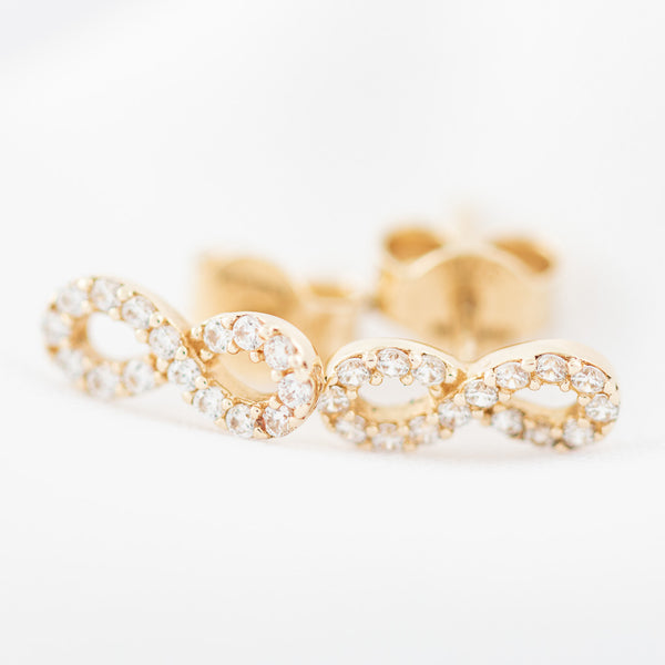 Aretes diseño especial con circonias motivo infinito en oro amarillo 14 kilates.