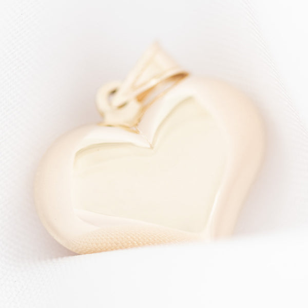 Dije hueco motivo corazón en oro amarillo 14 kilates.