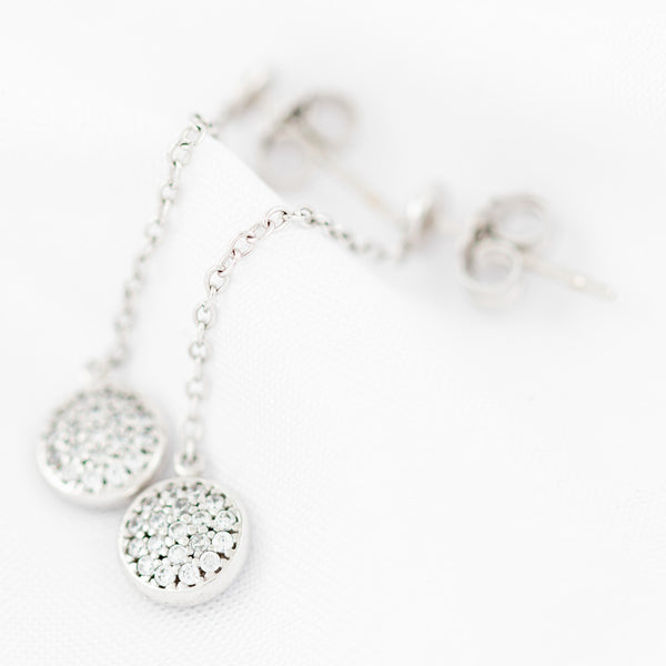 Aretes diseño especial con colgante de circonias en oro blanco 14 kilates.