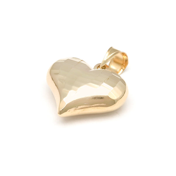 Dije hueco motivo corazón en oro amarillo 14 kilates.