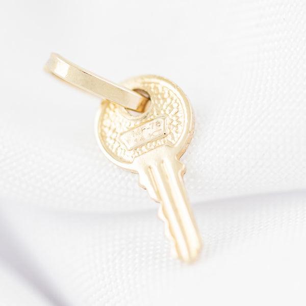 Dije diseño especial motivo llave en oro amarillo 14 kilates.
