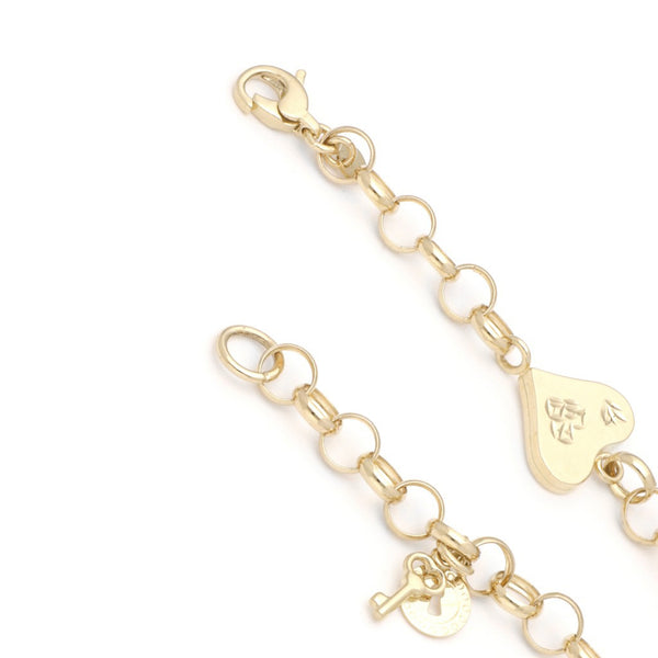 Pulsera eslabón cruzado con aplicación y colgantes motivo candado y llave en oro amarillo 14 kilates.