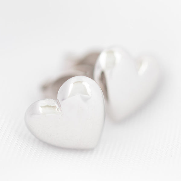 Aretes lisos motivo corazón en oro blanco 14 kilates.