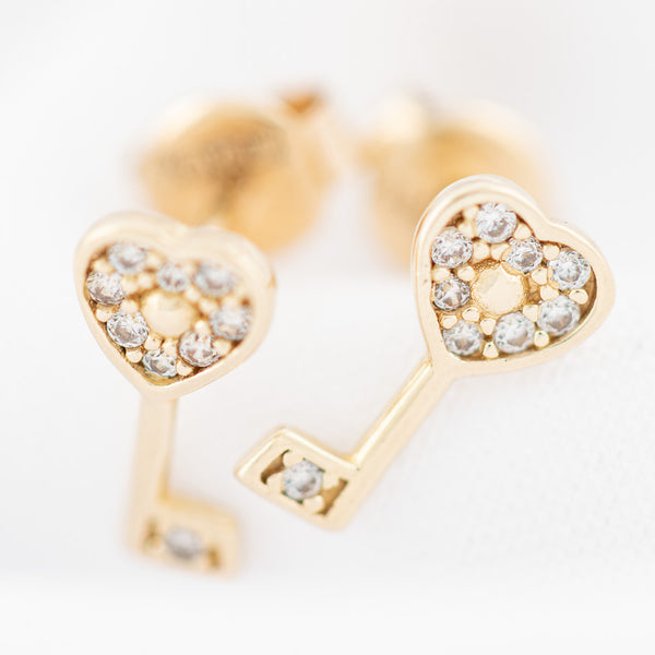 Aretes diseño especial motivo llave con circonias en oro amarillo 14 kilates.