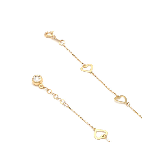 Pulsera eslabón cruzado con aplicaciones motivo corazón y sintético en oro amarillo 14 kilates.