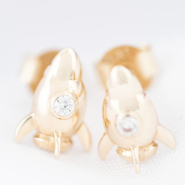 Aretes diseño especial motivo cohete con circonias en oro amarillo 14 kilates.