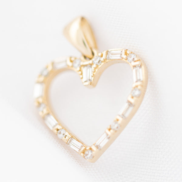 Dije diseño especial motivo corazón con circonias en oro amarillo 14 kilates.