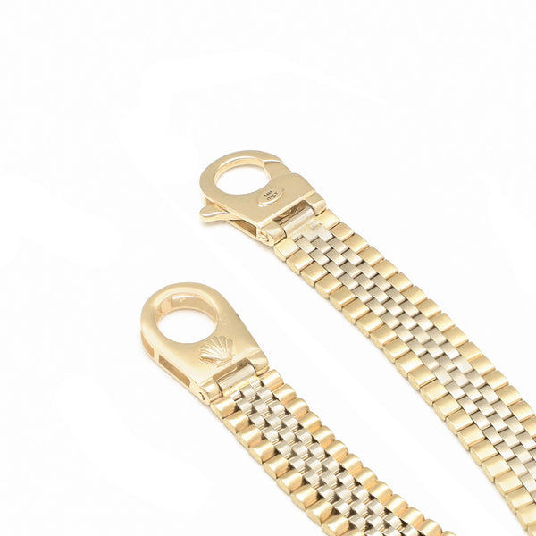 Pulsera eslabón articulado con aplicación motivo corona en oro dos tonos 14 kilates.