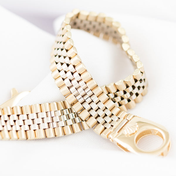 Pulsera eslabón articulado con aplicación motivo corona en oro dos tonos 14 kilates.