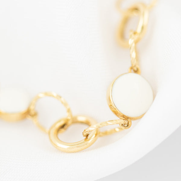 Pulsera eslabón cruzado con aplicaciones y sintéticos en oro amarillo 14 kilates.