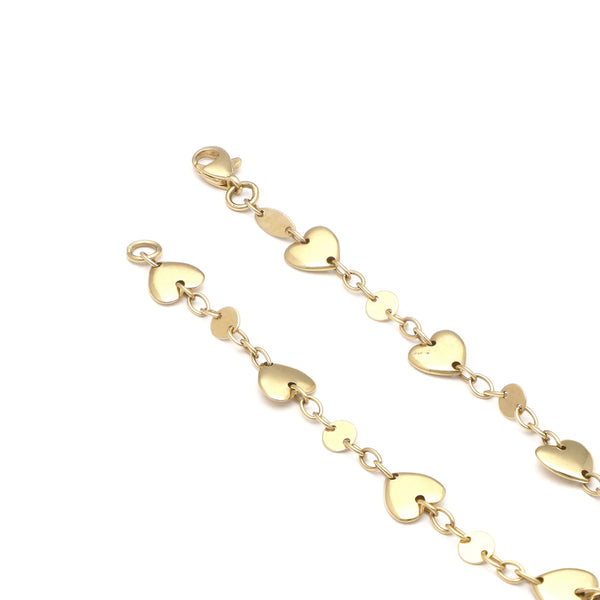 Pulsera eslabón cruzado con aplicaciones motivo corazón en oro amarillo 14 kilates.