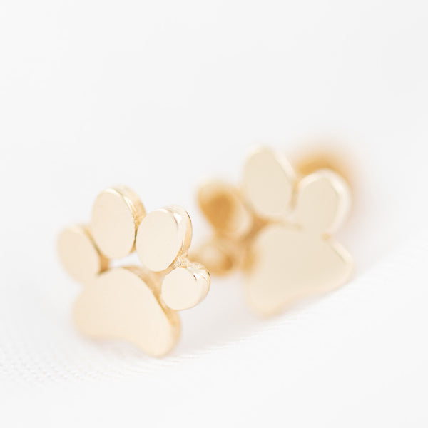 Broqueles lisos motivo huella de perro en oro amarillo 14 kilates.
