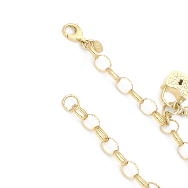 Pulsera eslabón cruzado con colgantes motivo llave y candado en oro amarillo 14 kilates.