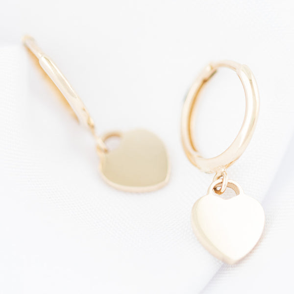 Arracadas articuladas con colgante motivo corazón en oro amarillo 14 kilates.