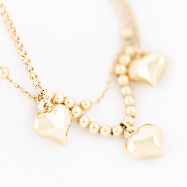 Pulsera de dos hilos eslabón combinado con aplicaciones y colgantes motivo corazón en oro amarillo 14 kilates.