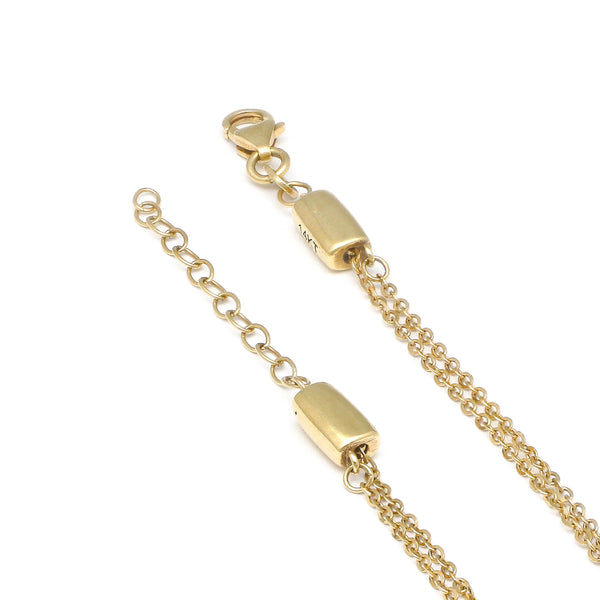Pulsera de dos hilos eslabón cruzado con aplicación motivo corazón en oro amarillo 14 kilates.