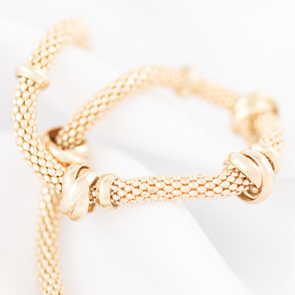 Pulsera eslabón tejido con aplicaciones en oro amarillo 14 kilates.