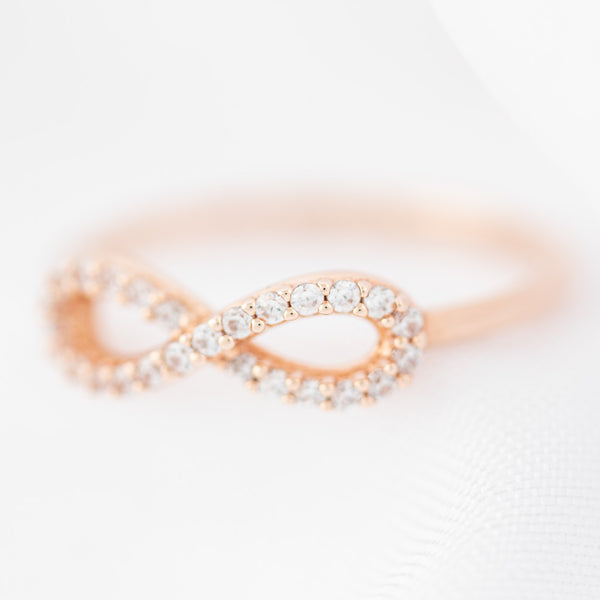 Anillo calado motivo infinito con circonias en oro rosa 14 kilates.