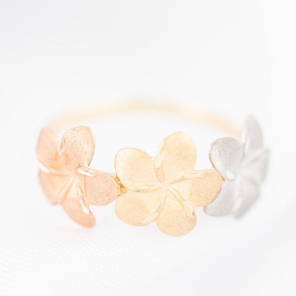 Anillo diseño especial motivo flores en oro tres tonos 14 kilates.