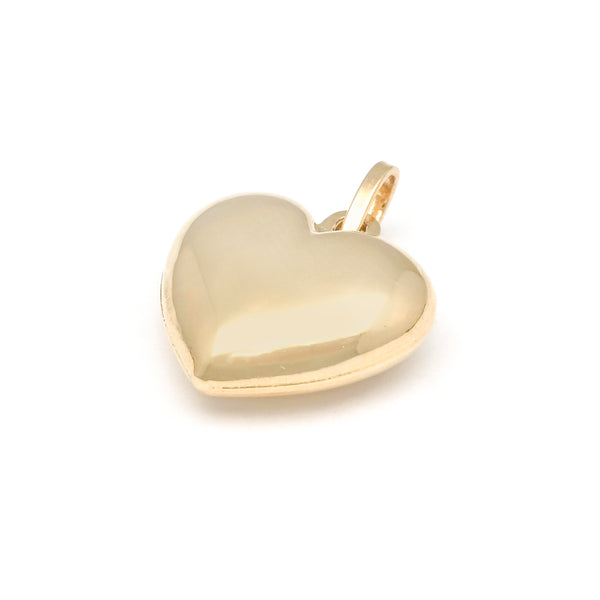 Dije hueco motivo corazón en oro amarillo 14 kilates.