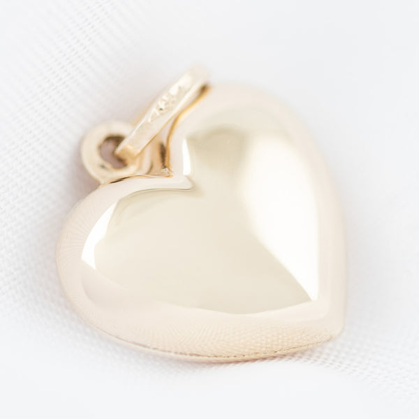 Dije hueco motivo corazón en oro amarillo 14 kilates.