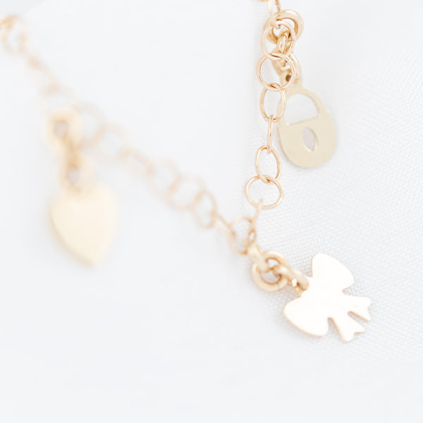 Pulsera eslabón cruzado con colgantes motivo diversas figura en oro amarillo 14 kilates.