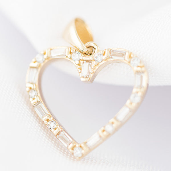 Dije diseño especial motivo corazón con circonias en oro amarillo 14 kilates.
