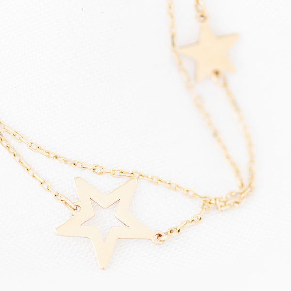 Pulsera de dos hilos eslabón cruzado con aplicaciones motivo estrellas en oro amarillo 14 kilates.