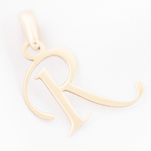 Dije liso motivo letra R en oro amarillo 14 kilates.