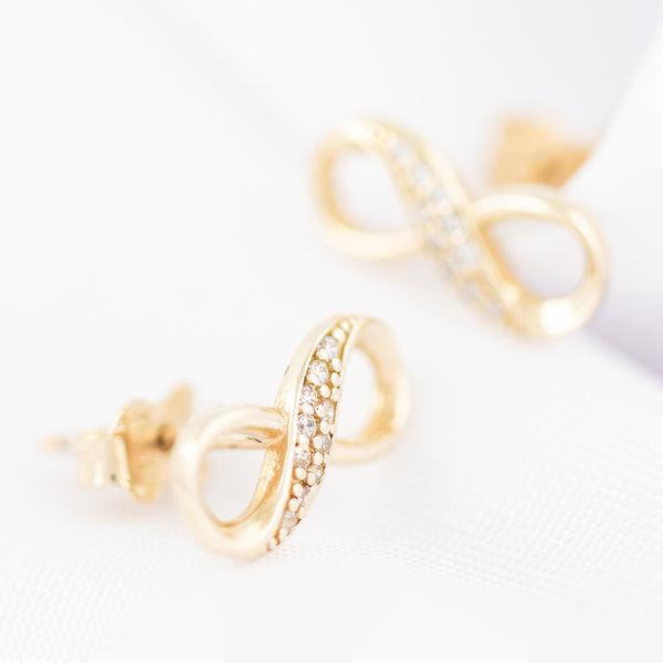 Aretes diseño especial con circonias motivo infinito en oro amarillo 14 kilates.
