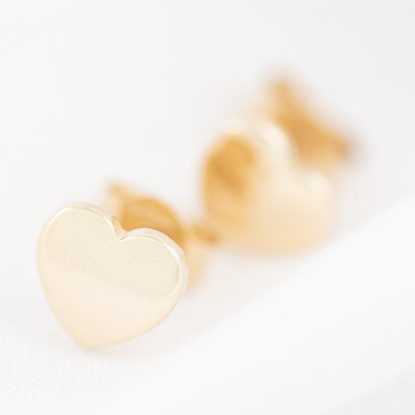 Aretes lisos motivo corazón en oro amarillo 14 kilates.